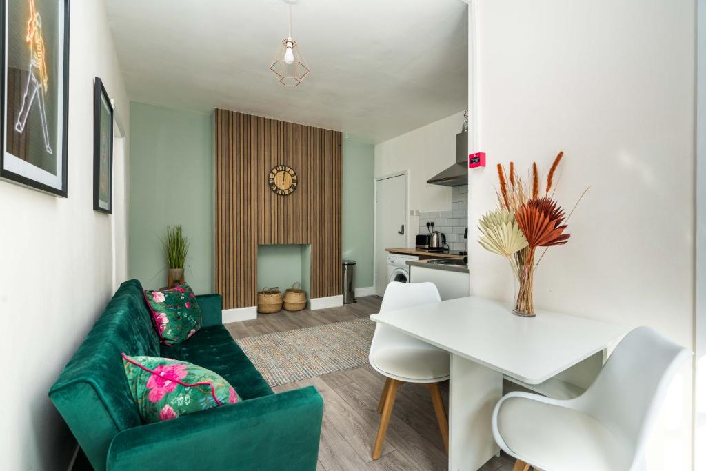 伦敦Shoreditch-bricklane-convenient-central-liverpoolstreet的客厅配有绿色沙发和白色桌子