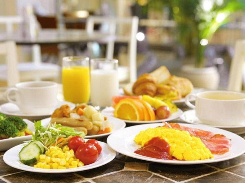 巴库老城酒店的餐桌上摆放着早餐食品和橙汁盘