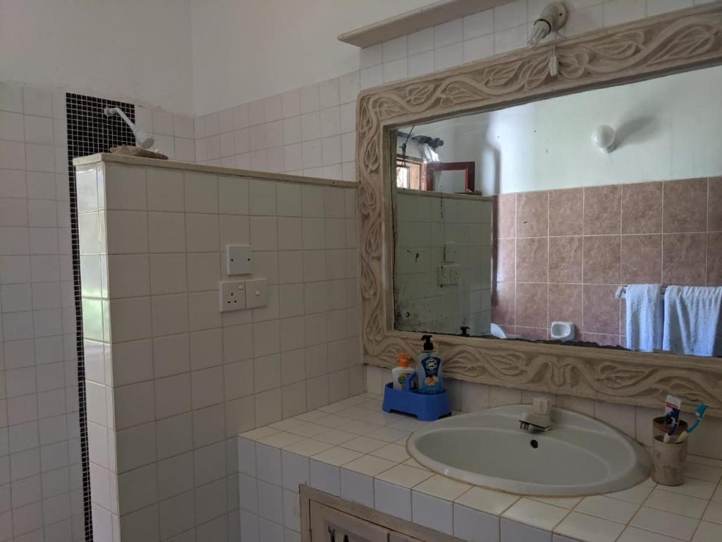 马林迪Karibuni Villa - Malindi beach view property的一间带水槽和镜子的浴室