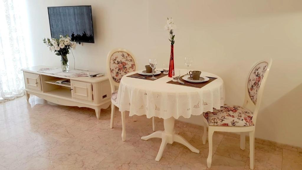 第聂伯罗基洛夫公寓酒店的用餐室配有带2把椅子的桌子和鲜花桌