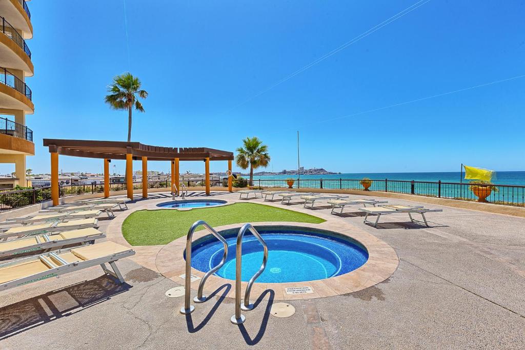 佩尼亚斯科港Sonoran SKY #910的一个带游泳池和椅子的度假胜地和大海