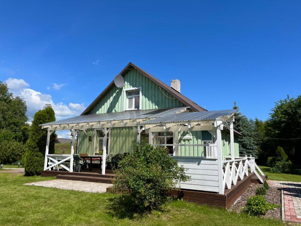 VilusiRähni Guesthouse Lake Peipsi的绿色白色的房子,设有门廊