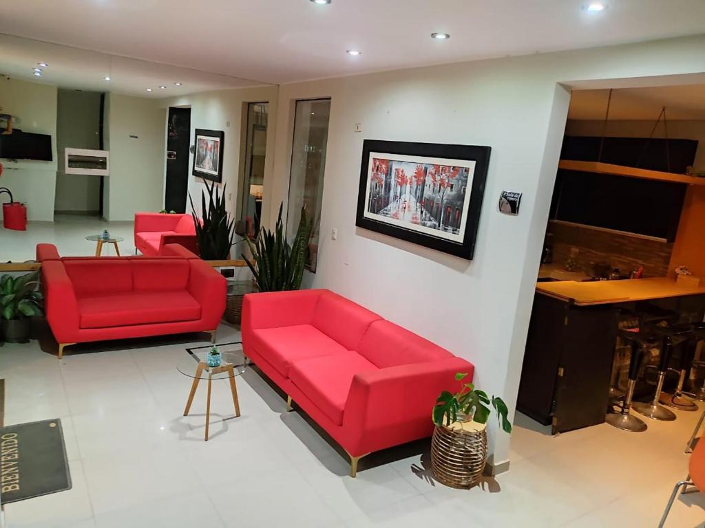 伊察Hotel Kallma Adventures的客厅配有两张红色的沙发和一张桌子