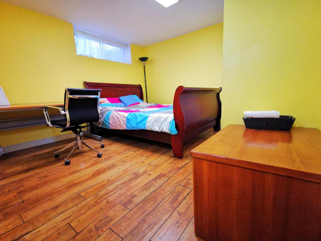 多伦多one queen-sized bed convenient location的一间卧室配有一张床、两把椅子和一张书桌