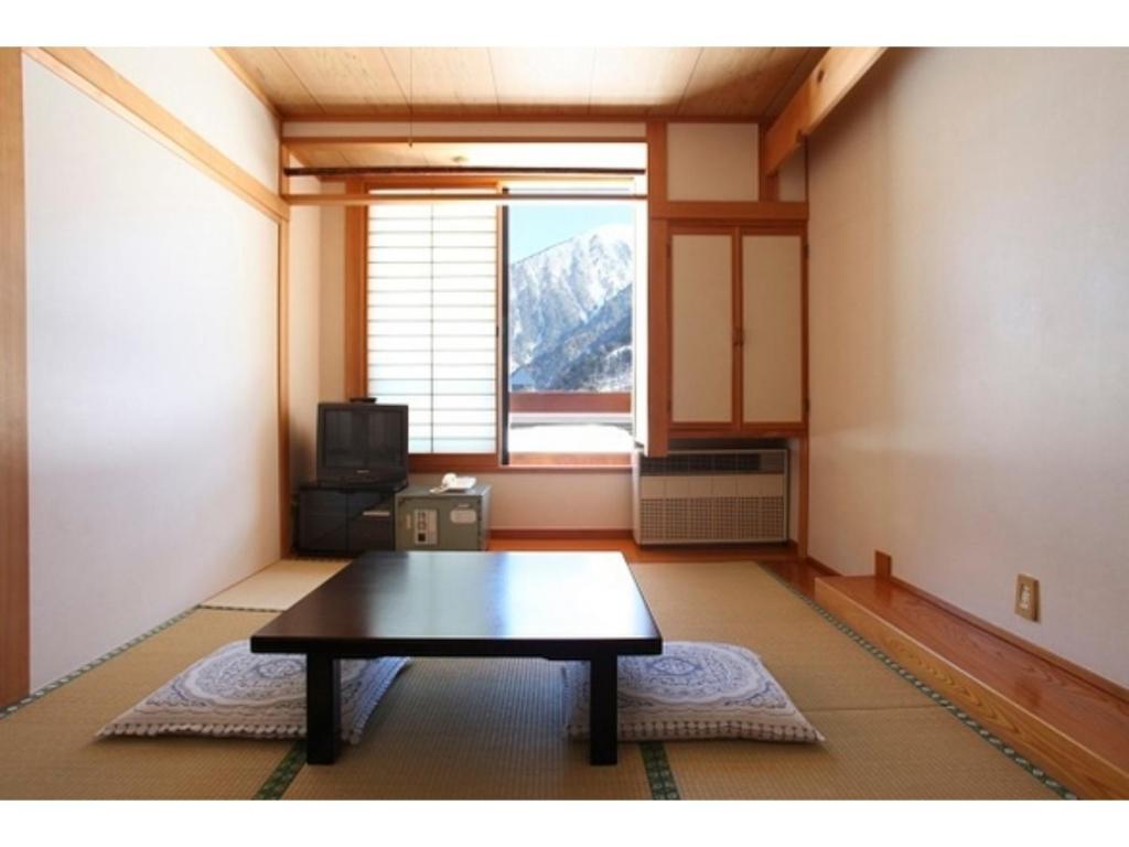 松本Nakanoyu Onsen Ryokan - Vacation STAY 07485v的客厅配有桌子和窗户
