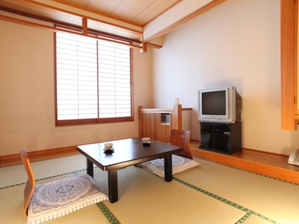 松本Nakanoyu Onsen Ryokan - Vacation STAY 07496v的客厅配有桌子和电视