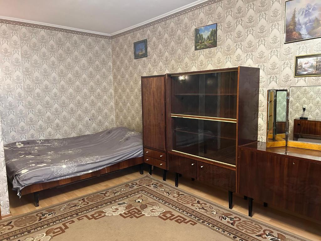 苏梅Недорога квартира на Харківській, 32的一间卧室配有一张床和一个木制橱柜
