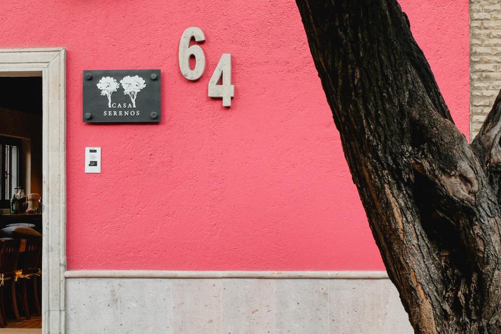 墨西哥城Casa Serenos的粉红色的墙,上面有标志