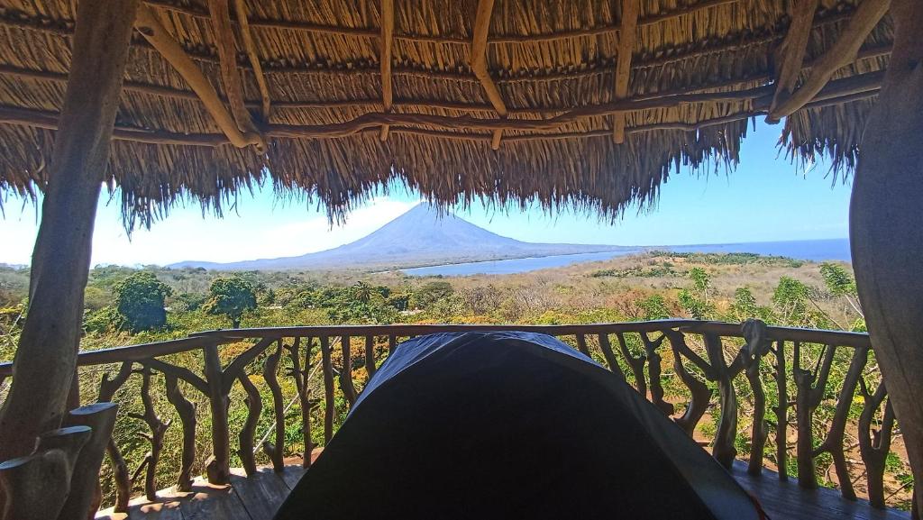 BalgueHostel & Camping Sol Y Luna Ometepe的躺在门廊上的人,享有山景