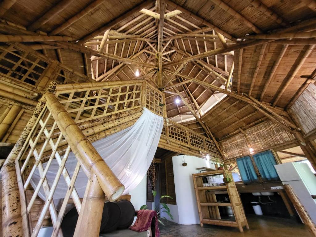 圣卡塔利娜岛Eco-Lodge Deseo Bamboo的木天花板的客房内的一张床位
