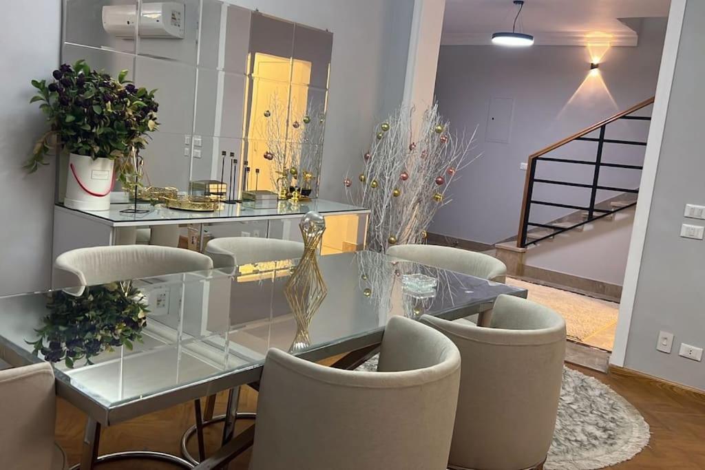 Sheikh Zayedدوبلكس اربع غرف بيفرلي هيلز ويست تاون فرش عالي جدا的一间设有玻璃桌和椅子的用餐室