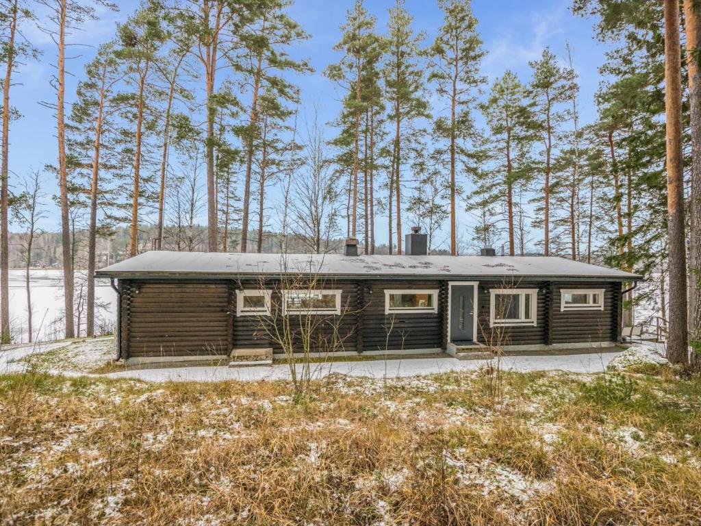 NummiHoliday Home Villa lahnajärvi by Interhome的树林中的小屋,有树木背景