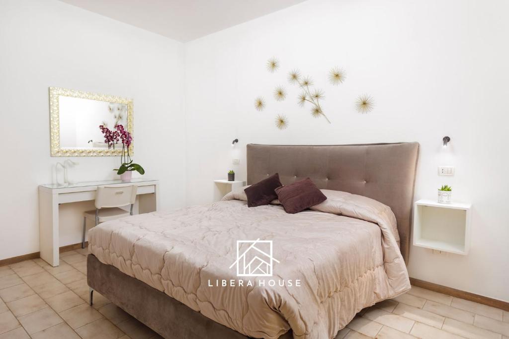 圣萨尔沃LIBERA HOUSE - Sweet Apartments的一间卧室配有一张床、一张桌子和一张四柱床。