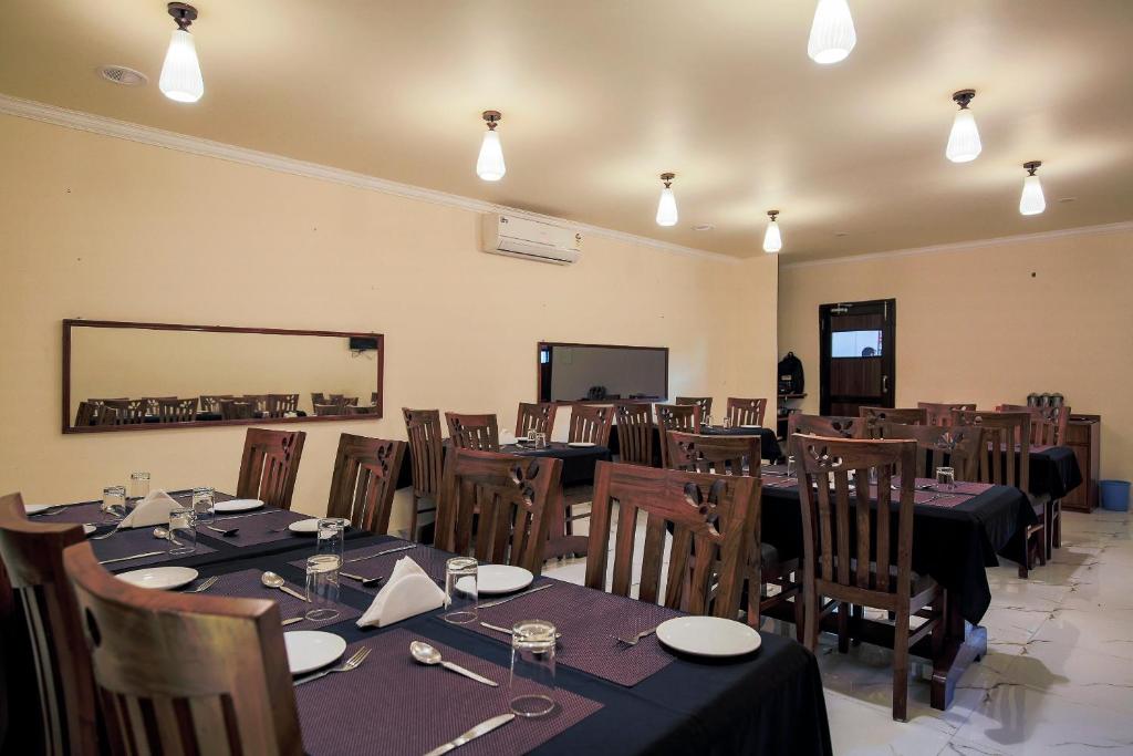 马尔冈Collection O Hotel Sincro的用餐室配有桌椅和灯光