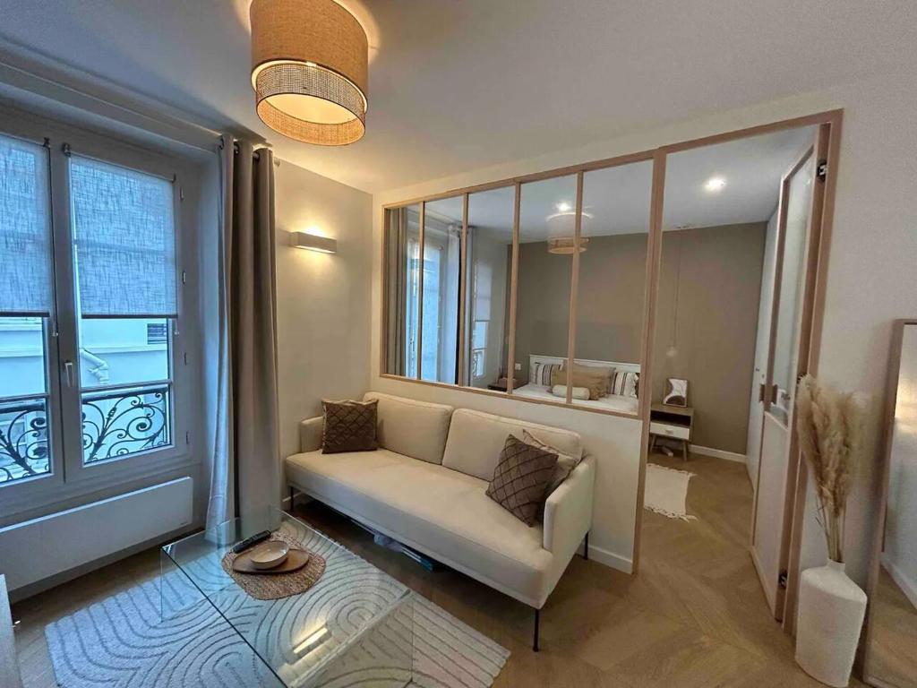 巴黎Cocooning & Cosy Apartment in Center Paris 17的带沙发和大窗户的客厅