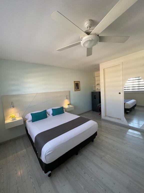 瓜达拉哈拉Constanza Lofts Executives en Zapopan Jalisco的一间卧室配有一张大床和吊扇