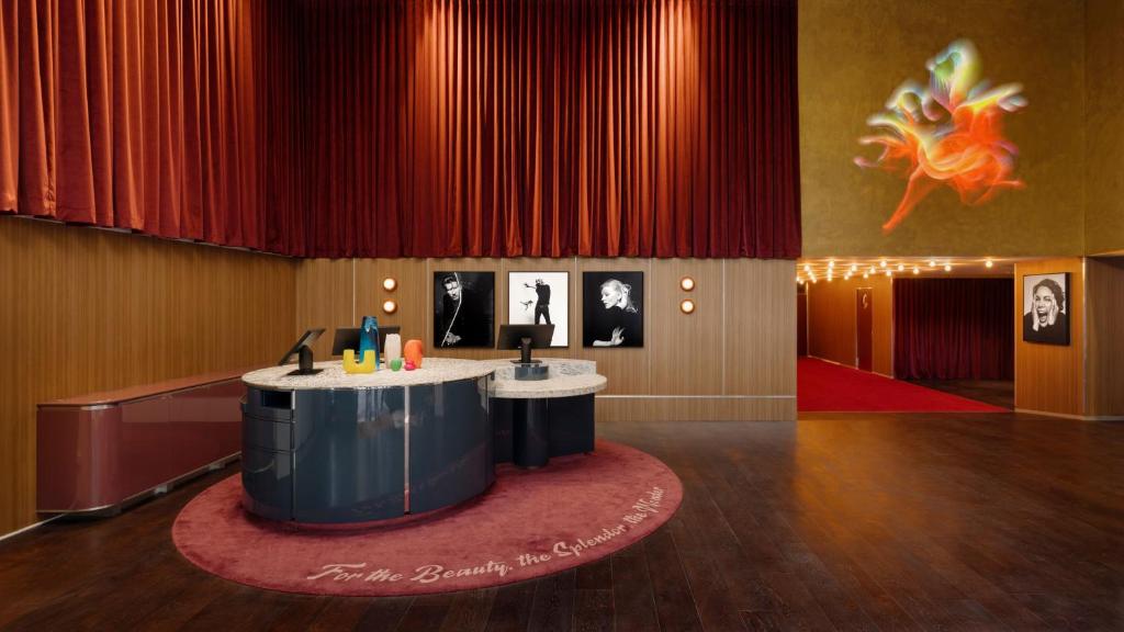 悉尼悉尼蓝塞瑞拉莫特酒店的一个带圆桌的舞台,位于一个红色窗帘的房间
