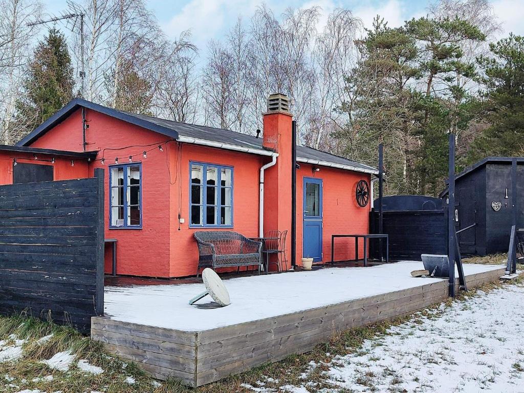 维斯特索马肯Holiday home Aakirkeby VIII的一座红色的小房子,有雪盖的院子