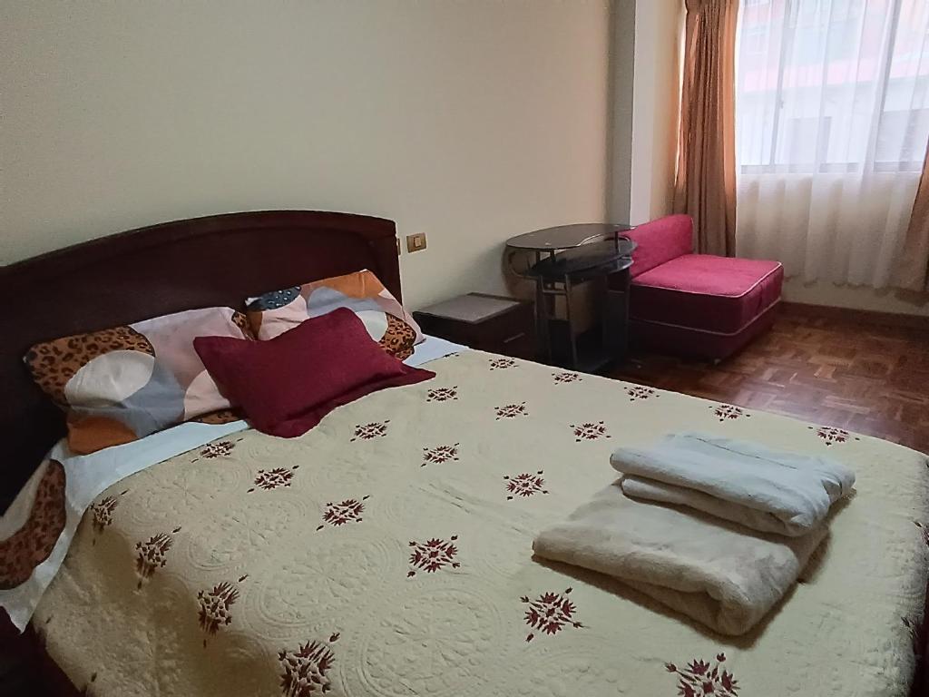 波托西Apartamento cómodo的一间卧室配有带毯子和枕头的床。