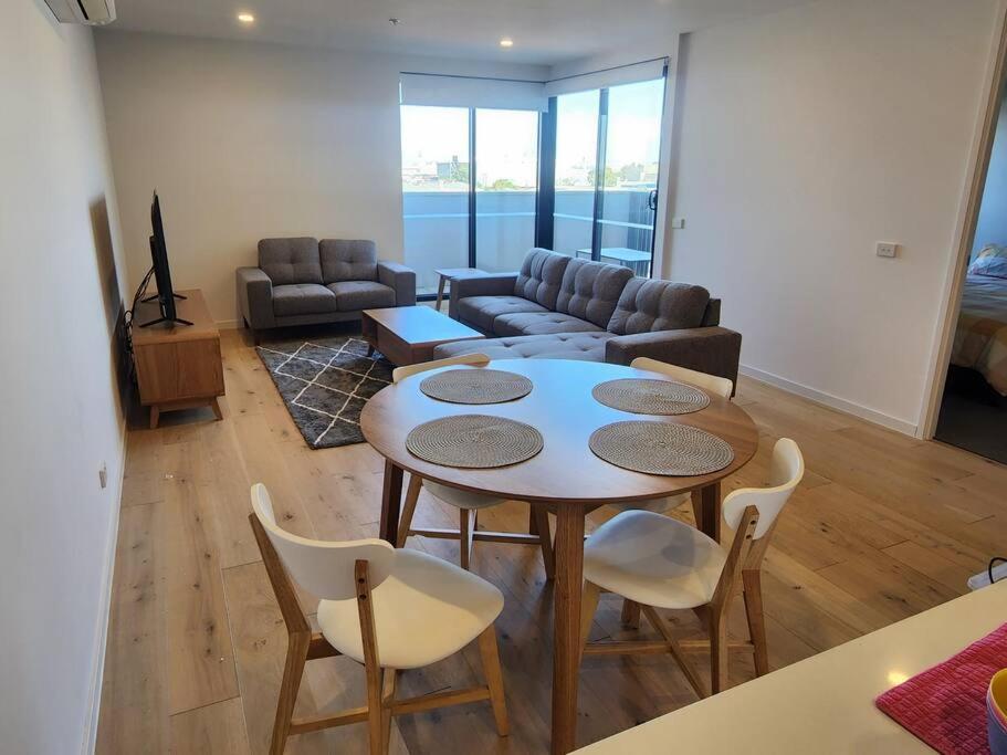 墨尔本Modern Apartment Airport Area的客厅配有桌椅和沙发