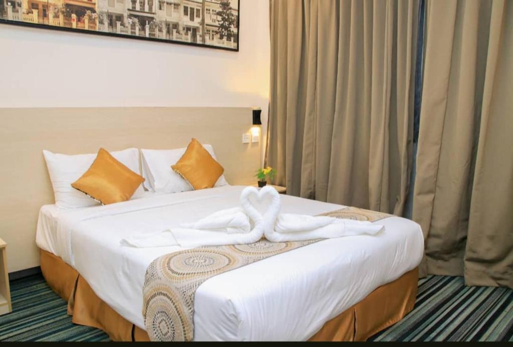 吉隆坡bintang hotel的酒店客房带一张大床,带白色床单
