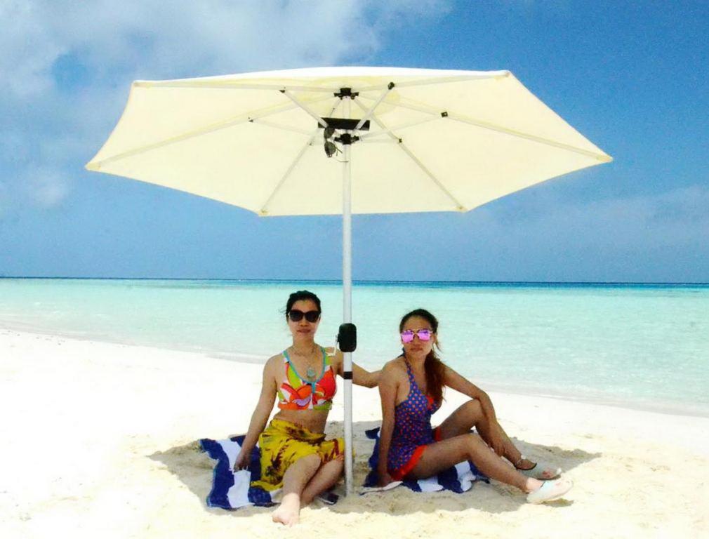 古雷德胡Adroit Beach Inn的两名妇女在海滩上被伞下