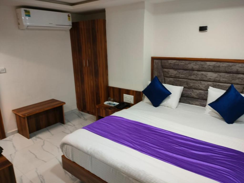 艾哈迈达巴德Hotel Palak Palacce的一间卧室配有一张带蓝色枕头的大床