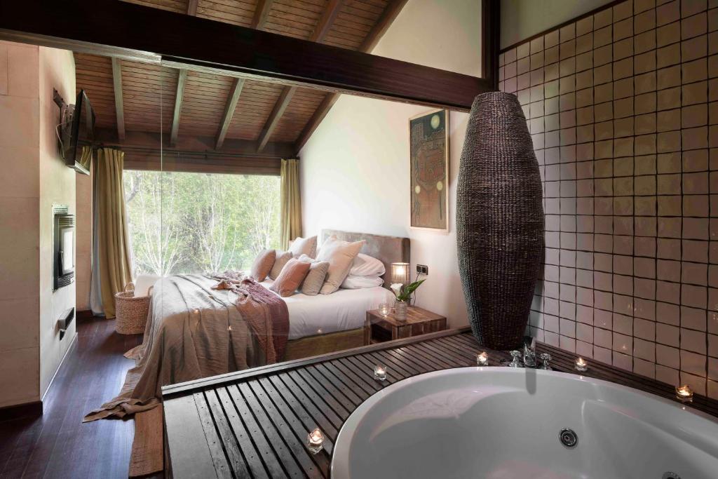 Lugás卢卡斯庭院旅馆的一间带浴缸的浴室和一张位于客房内的床