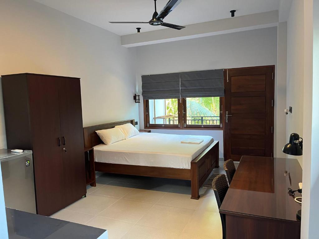 米迪加马东Cozy Corner - Midigama的一间卧室设有一张床和一个窗口