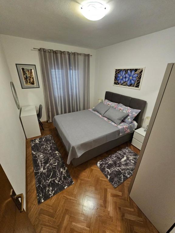 特罗吉尔格吉奇公寓的一间卧室配有一张床和两块地毯