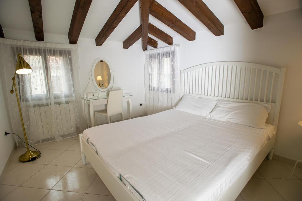 基奥贾Ca' Arte e Vacanze MyTravelChioggia的卧室配有白色的床和镜子