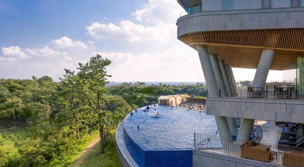西归浦市大自然隐藏悬崖酒店 的享有度假村游泳池的景致
