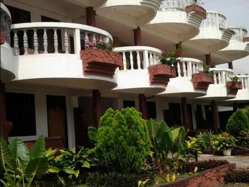 巴拉巴特Darma Agung Beach Hotel Parapat的一座带阳台的建筑,上面有盆栽植物