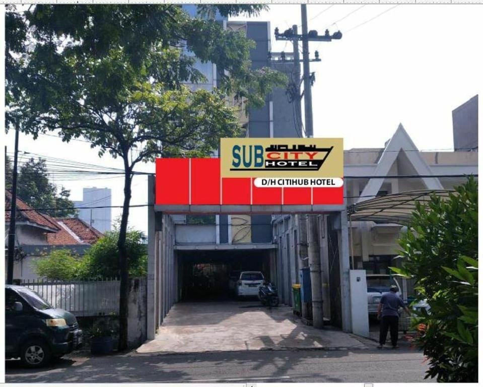 泗水Sub City Hotel的汽车车库子商店的标志