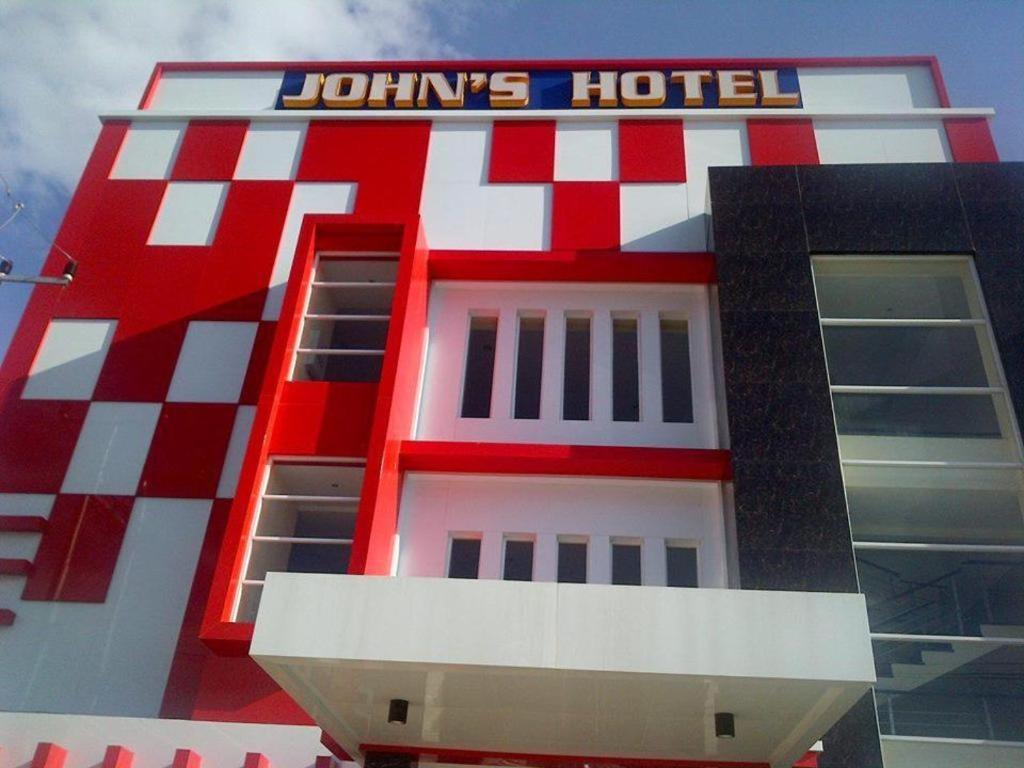MaulafaJohn's Hotel的一座红白色的建筑,上面有酒店标志