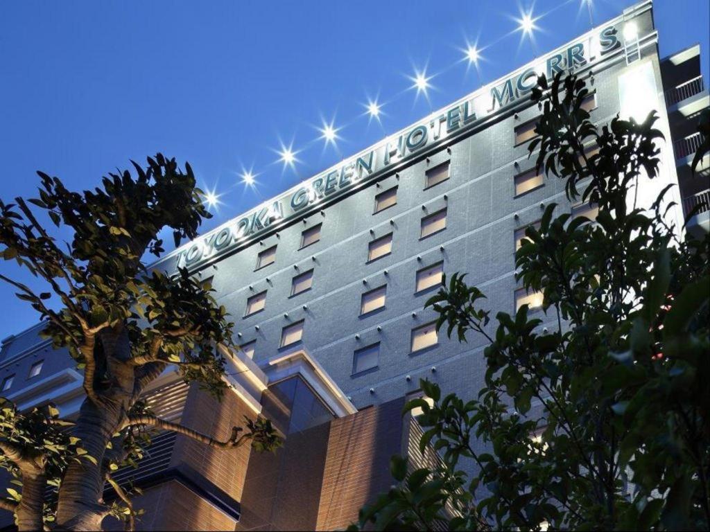 丰冈市Toyooka Green Hotel Morris的建筑的侧面有标志