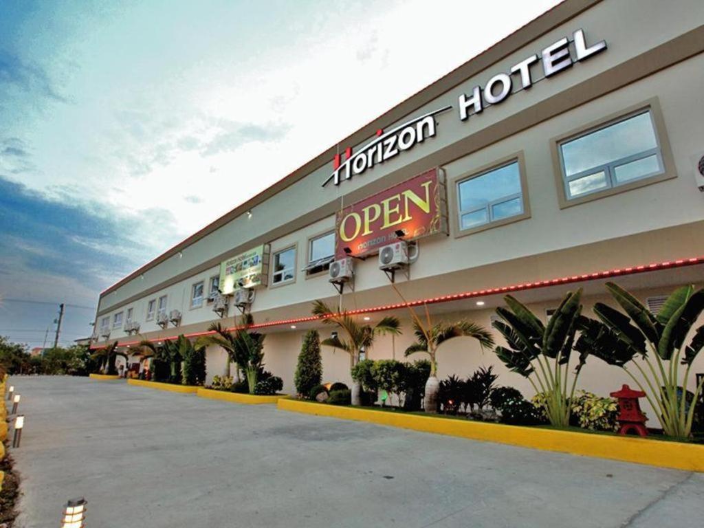 奥隆阿波Horizon Hotel的一边有开放式标志的酒店