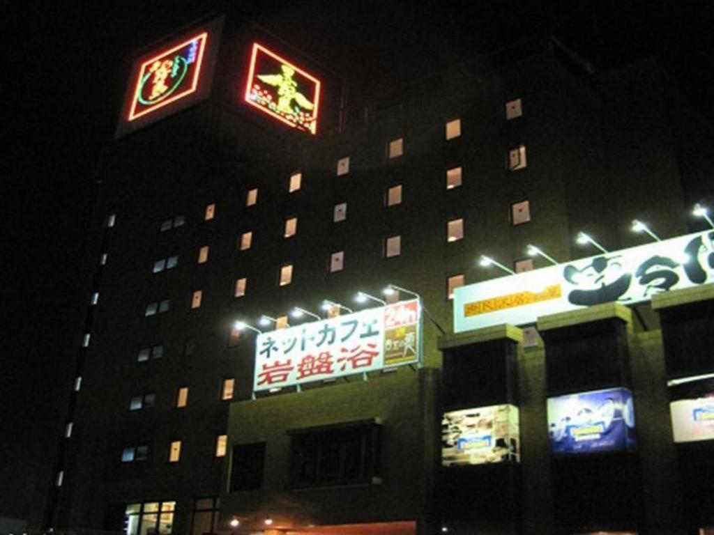 都城市Miyakonojo Sun Plaza Hotel的一座建筑物,晚上有标志