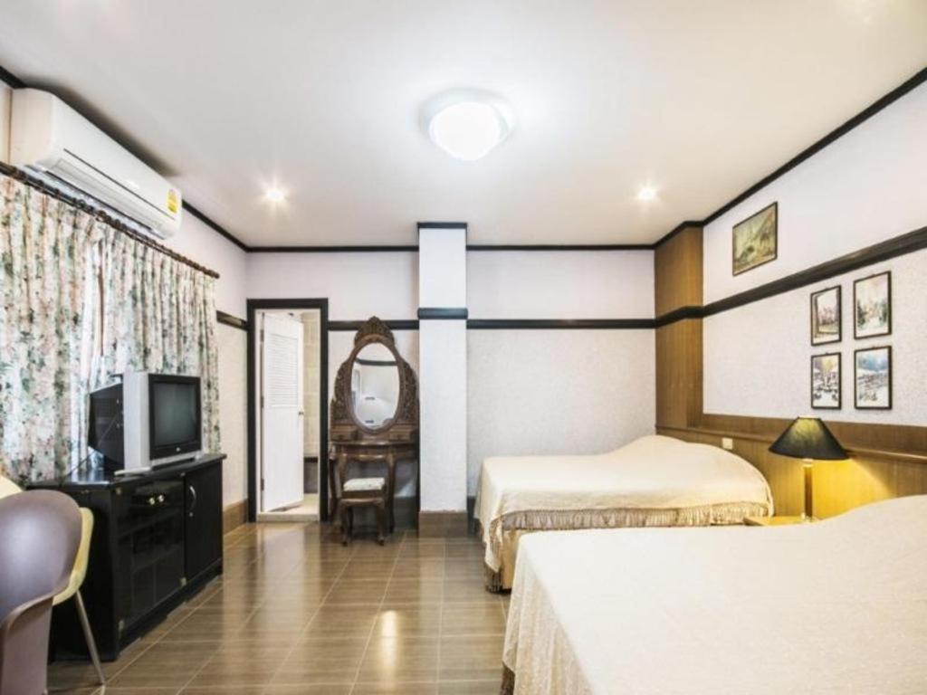Ban Rong ChangNumsin Hotel的酒店客房设有两张床和电视。
