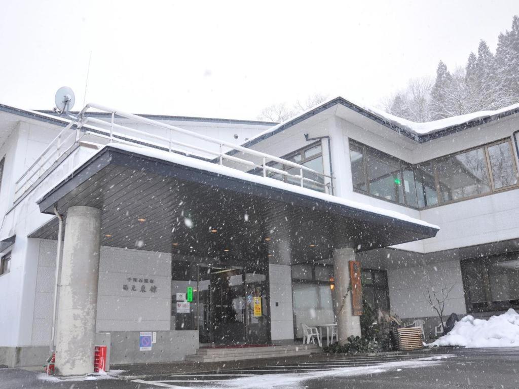 OniyanagimachiSenganishi Onsen Yumoto Azumakan的一座雪落在前面的建筑