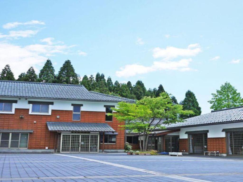 ItoOtaiko Hills的一座红砖建筑,有树为背景