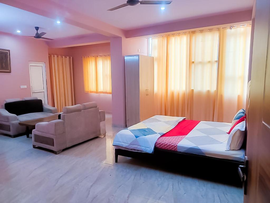新德里Bharat Vandana Stay near Yashobhoomi的一间卧室配有一张床、一张沙发和一把椅子