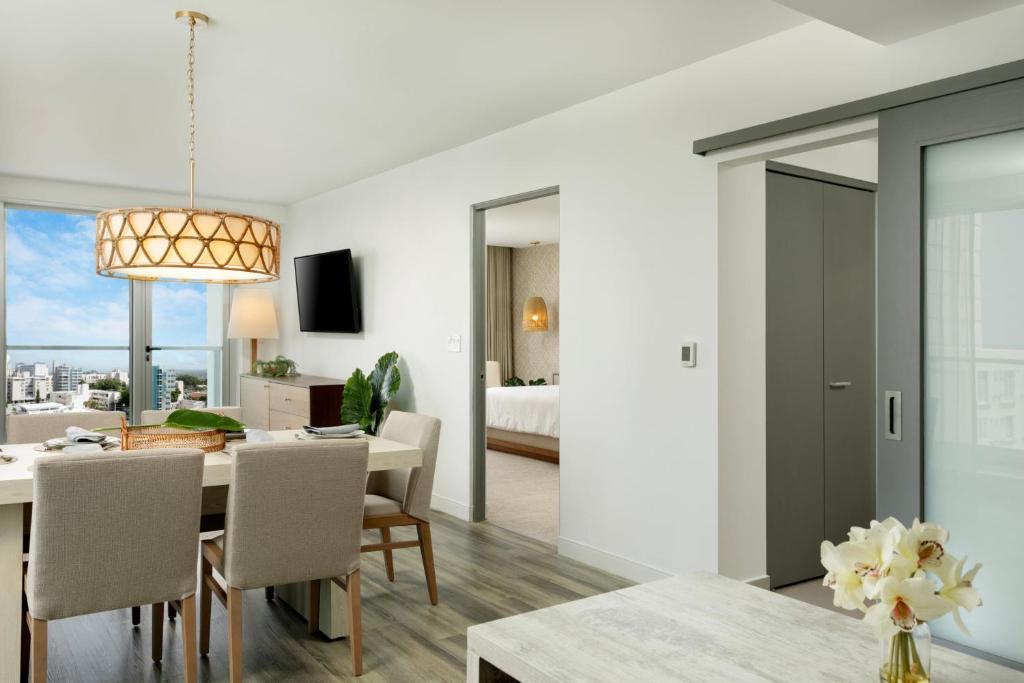 圣胡安Casa Costera, Isla Verde Beach, Apartments by Marriott Bonvoy的用餐室以及带桌椅的起居室。