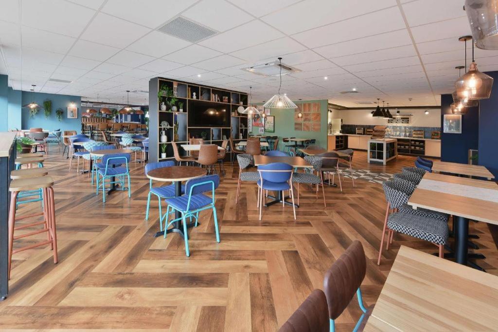 SheldonTravelodge Birmingham Airport的一间在房间内配有桌椅的餐厅
