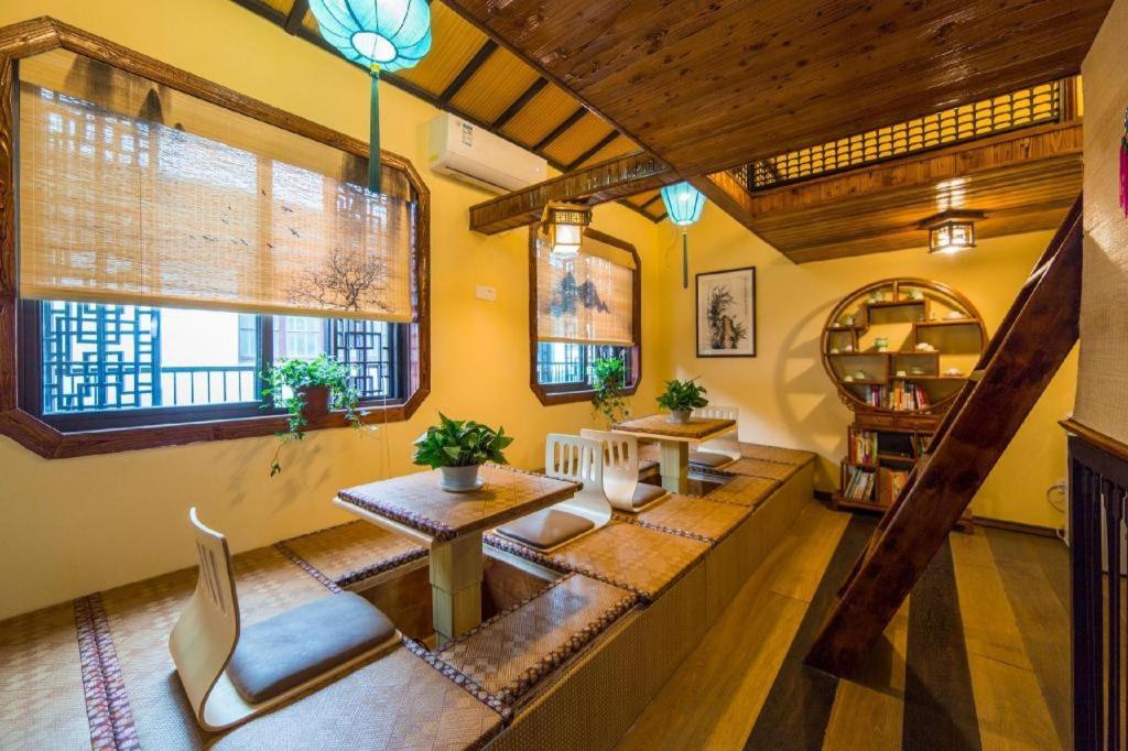 苏州The Courtyard Suzhou Inn Hemu Branch的客厅拥有黄色的墙壁和木制天花板。