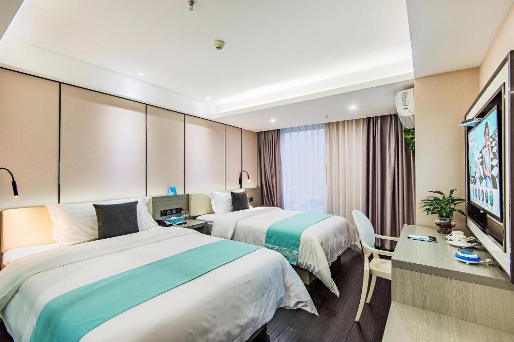 双流Xana Lite Chengdu Shuangliu Airport Haibin City Branch的酒店客房设有两张床和一台平面电视。