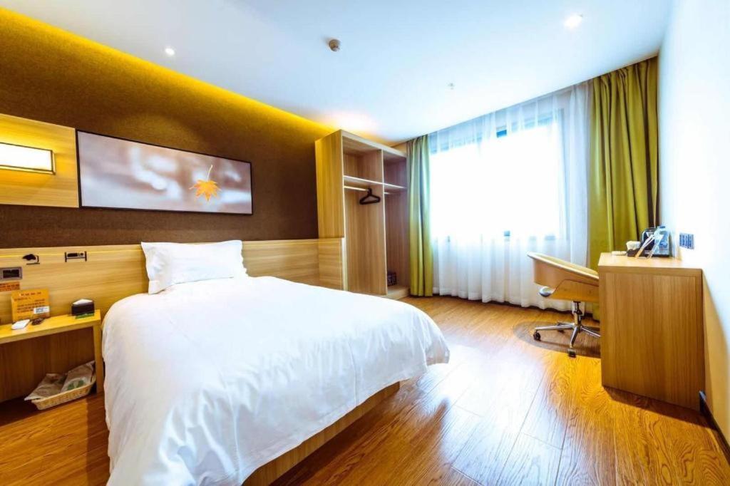 鸳鸯桥IU Hotel Chongqing Jiangbei International Airport的卧室配有白色的床、书桌和窗户。