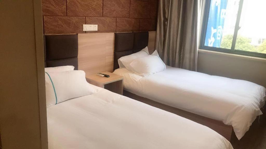 上海Shanghai Jiejia hotel的酒店客房设有两张床和窗户。