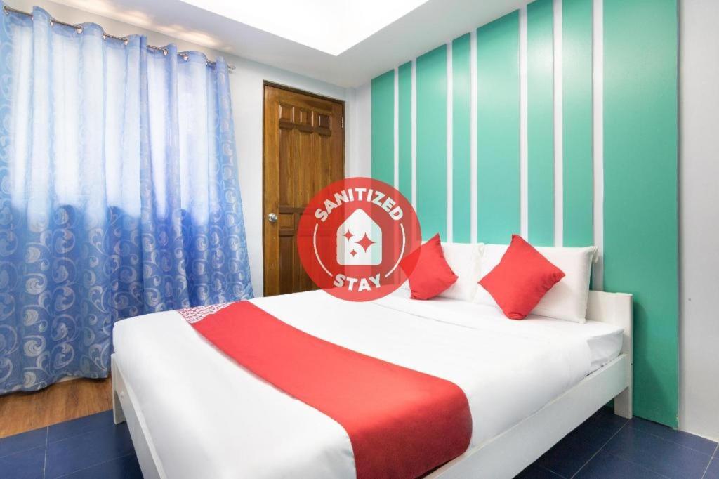 马尼拉OYO 128 d'Builders Rooms Phase 2的一间卧室配有红色和白色枕头的床