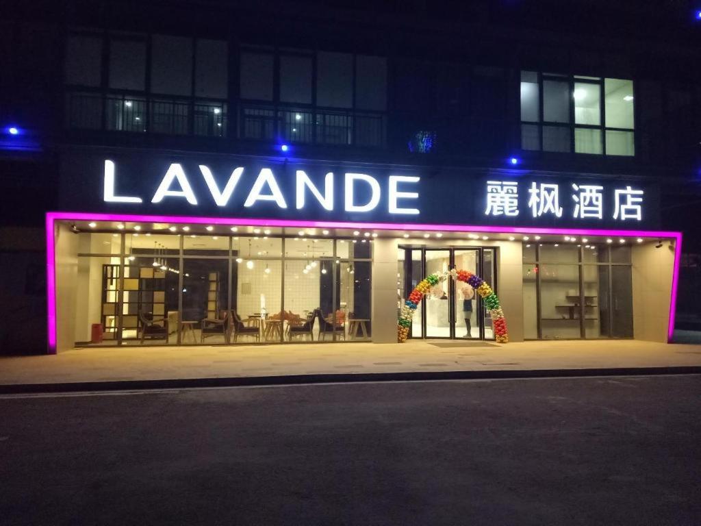 徐州Lavande Hotels·Xuzhou New District Meidi Square的带有夜间读取乐凡达明标志的建筑物